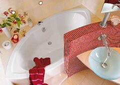 ovale Badewanne hinter Mauer mit roten Mosaiksteinen, Waschtisch