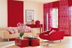Red and pink living room with armchair, sofa and Buddha head statue on table