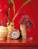 Close-up of ginger flowers and pink pepper in bamboo vases