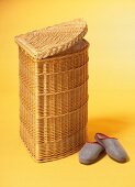 Laundry bin with slipper on yellow background