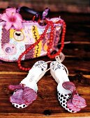 Sandals decorated with jungle flower and handbag on wood