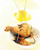 Chicken drumsticks and lemon on serving dish