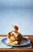 A baked potato in baking paper with smoked salmon and creme fraiche