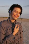 Janine Frau hört am Strand Musik