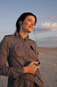 Janine Frau hört am Strand Musik