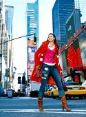 Frau im Mantel, Rock + hochhackigen Stiefeln, fröhlich in New York
