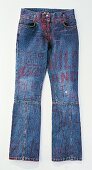 Blaue Jeans mit Nähten, mit roten Buchstaben bemalt