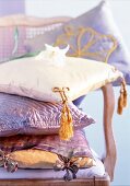 Close-up of purple oriental stacked cushions on chair