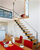 Küche mit Bar und Barhockern offene Treppe aus Holz nach oben