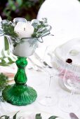 Close-up of lit candle in candlestick and wine glasses on festive table
