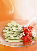 Sliced zucchini carpaccio with chopped tomatoes on glass plate