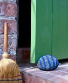 Doorstopper with blue felt stuck on stone in front of green door