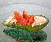 Halved avocado topped with chicken and grapefruit
