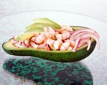 Halved avocado topped with radish, shrimp and red onions