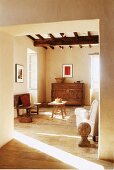 Wohnzimmer mit wenigen Möbeln in einem hellen Haus mit Steinboden