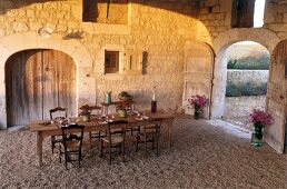 Laid table and chairs with autumnal decorations in old barn