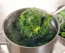 Cooked kale sieved out of cooking pot
