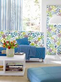 Living room with sofa, floral pattern fabrics on wall and striped curtains