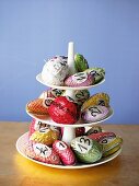 Close-up of advent calendar cake stand with multi-coloured paper mache cones and nuts