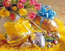 Close-up of golden pappeier with ribbons, Easter bunny, Easter eggs and tulips