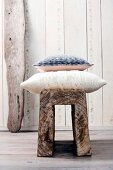 Two woollen knitted pillows on oak stool