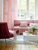 Living room with red and white striped sofa, pink armchair and fur carpet