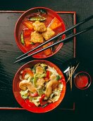 Sweet and sour pork with pineapple and chinese cabbage with chicken and vegetables in bowl