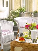 White wicker chairs with cushions and wicker table