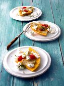 Three plates of Jerusalem artichoke kept on tomato tortilla on wooden surface