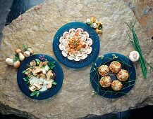 Three plates of mushroom carpaccio, porcini mushrooms in herb and stuffed mushrooms