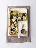Pieces of spinach and goat cheese tart on rectangle dish