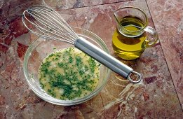 Spices and herbs vinaigrette in bowl with jug of oil, step 4