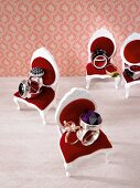 Set of silver and gold rings on dollhouse chairs