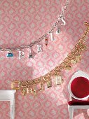 Close-up of silver and golden bracelets hanging on wall of doll house