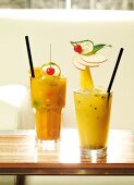 Two fruity cocktails in glasses on table