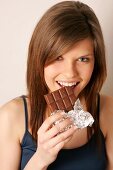 Portrait of woman with long hair eating chocolate, smiling