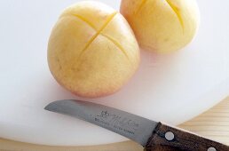 Close-up of crosswise carved apricots on white chopping board