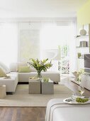 Living room with light green painted wall, white sofa and cushion