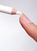 Nail tip is painted with white pencil against white background