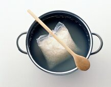 Cooking rice in cooking bag by hanging it on teapot