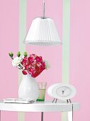 Vase, Lampe und Uhr in Weiß, Wand rosa mit Streifen in Grün