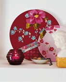 Floral patterned plates, bowl and lantern against white wall