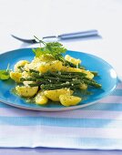 Beans and potato salad with parsley basil pesto on blue plate