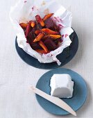 Beetroot and carrot salad in a parcel with goat cheese on a saucer