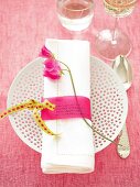 Napkin with pink menu card on plate with holes