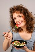 Janine schaut in die Kamera hält Salatschüssel in der Hand