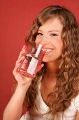 Sandra lacht und hält ein Glas Wasser in der Hand