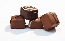 Close-up of stacked square shaped chocolates on white background