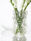 Glass vase with ornament made of woven glass cords