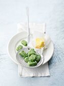 Fresh, homemade spinach gnocchi on a draining spoon